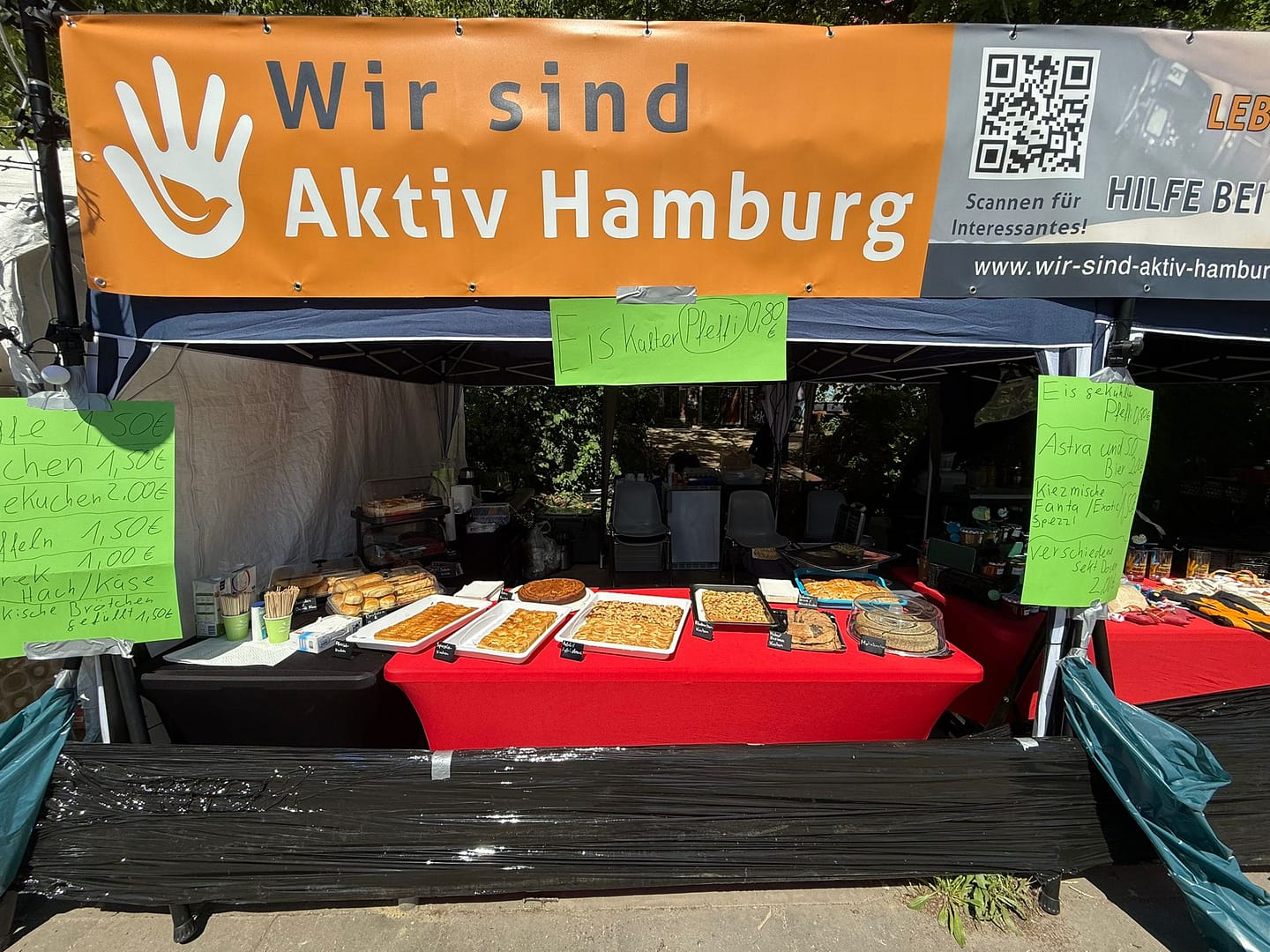 Infostand von Wir sind aktiv Hamburg beim alternativen Hafengeburtstag 2025 mit Kuchenbuffet und Glücksrad