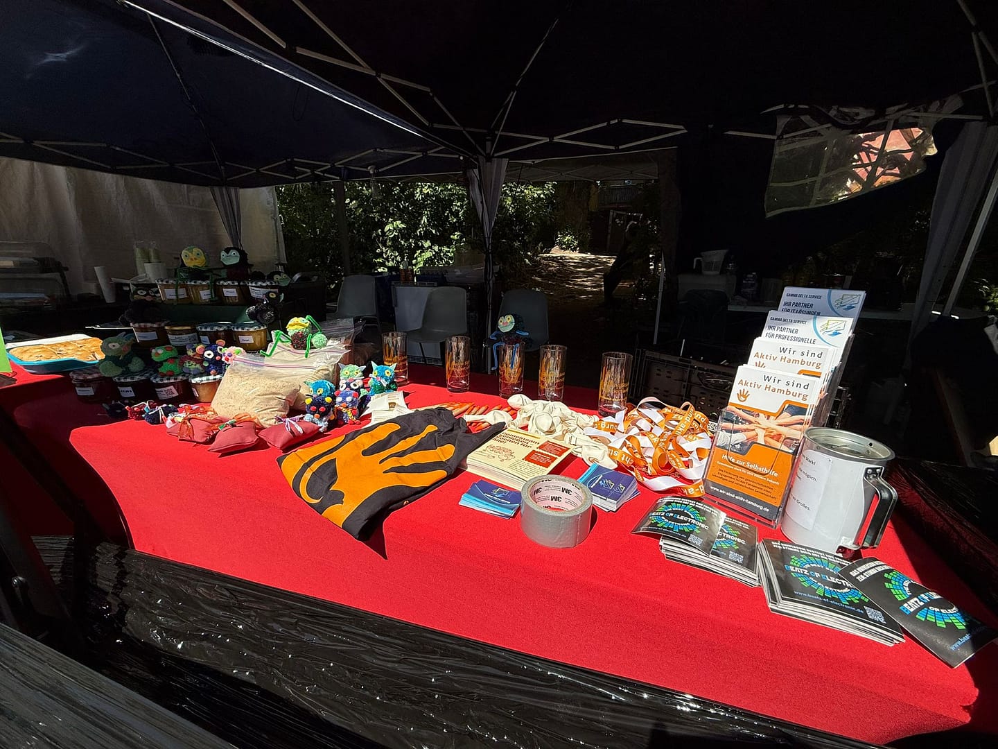 Infotisch mit Flyern, Broschüren, Giveaways und selbstgemachten Geschenken beim Stand von Wir sind aktiv Hamburg