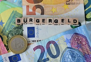Euro-Geldscheine und Münze mit dem Schriftzug „Bürgergeld“ – Symbolbild zur geplanten Nullrunde bei der Grundsicherung 2025